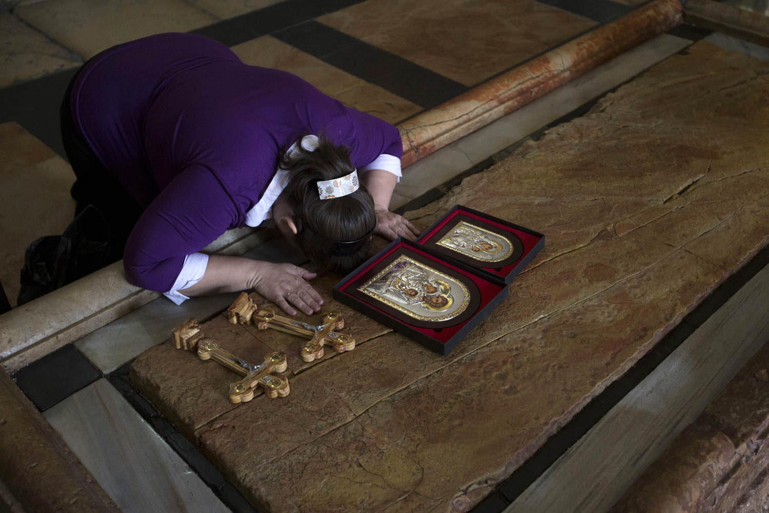 A Christian worshipper touches the Stone of Anointing in the Church of the Holy Sepulchre in Jerusalem's Old City