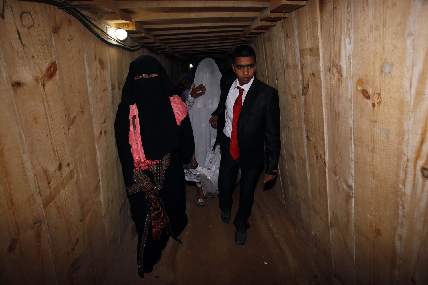 Palestinian groom Emad al-Malalha walks with Manal Abu Shanar his Egyptian bride inside a smuggling tunnel beneath the Gaza-Egypt border in the southern Gaza Strip