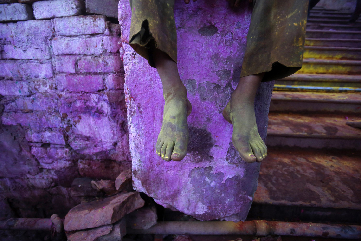 Coloured feet of a Hindu devotee are pictured outside a temple during "Lathmar Holi" at the village of Barsana