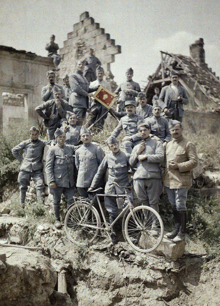 French officers of the 370th Infantry Regiment pose in the ruins after a German attack at the Chemin des Dames near Reims in 1917. They have a bicycle and the flag of the 370th Infantry Regiment. The region was one of the worst battle grounds on the Western Front during World War I.