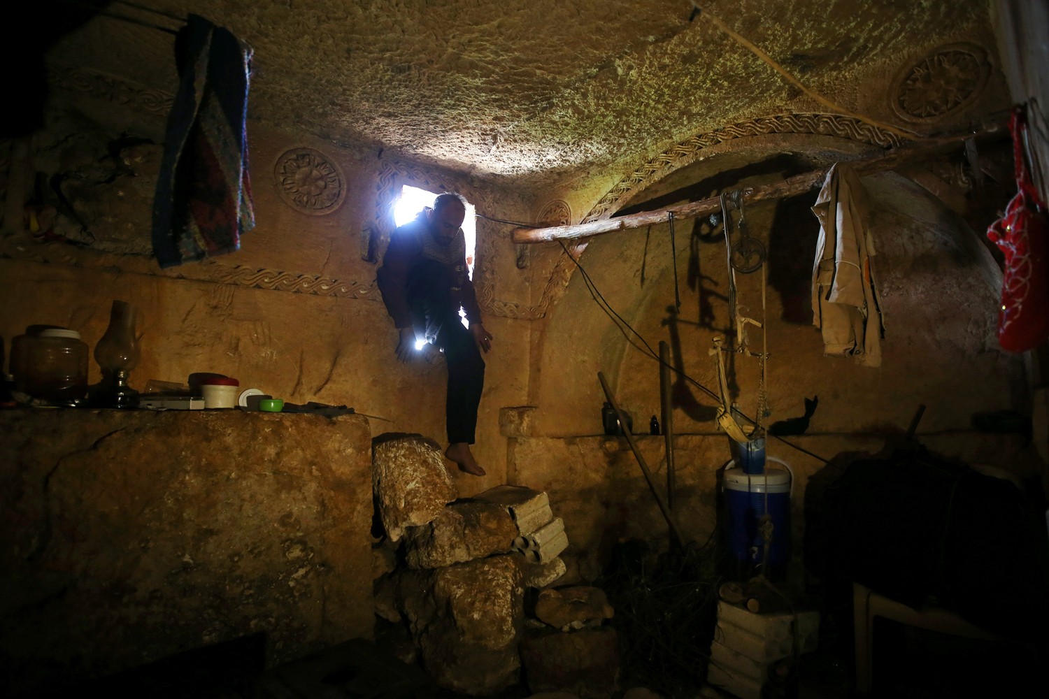 Feb. 28, 2013. Sami, 32, steps into an underground Roman tomb used for shelter from Syrian government forces shelling and airstrikes, at Jabal al-Zaweya, in Idlib province, Syria.