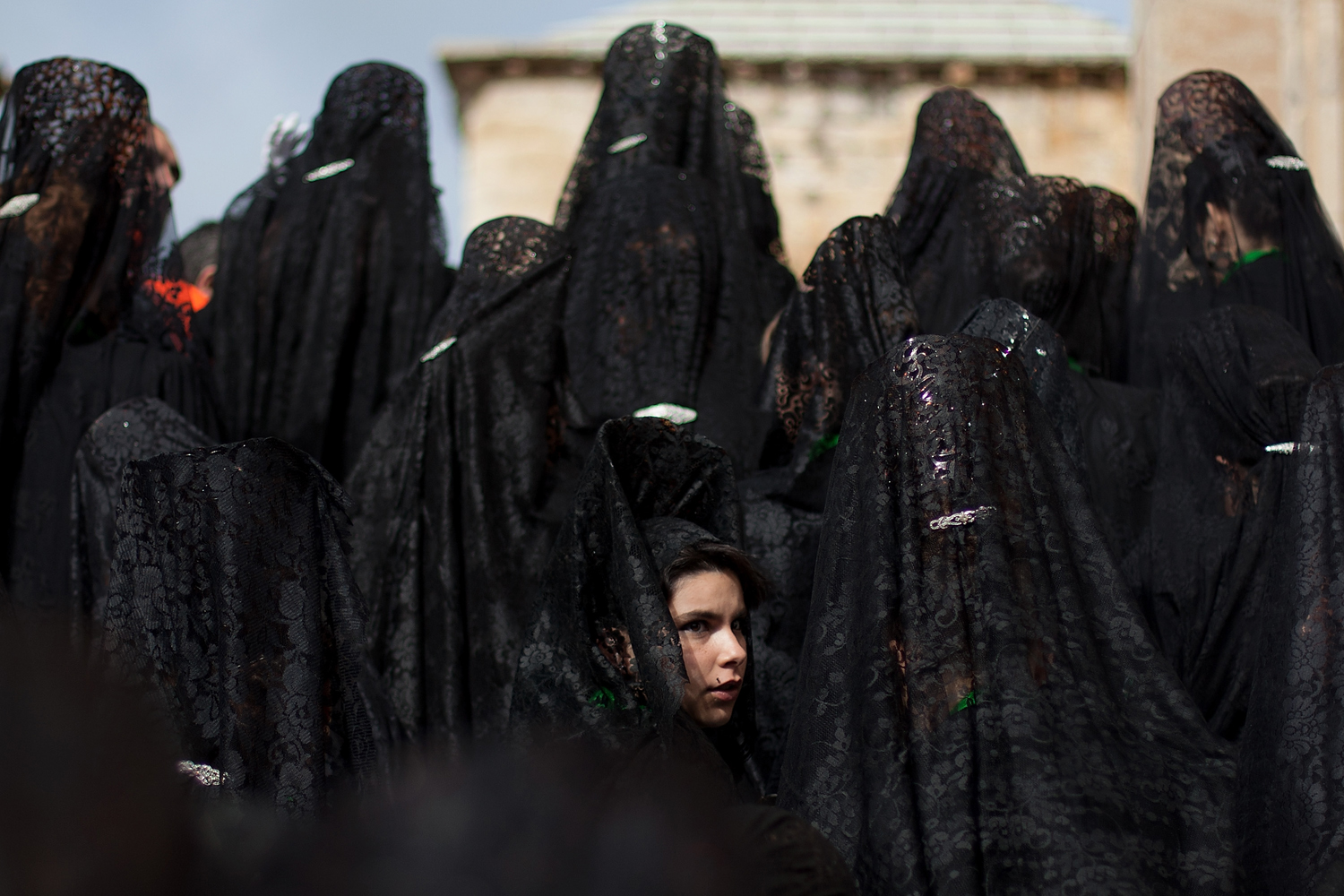 March 28, 2013. A penitent looks back as she and others wear mantillas, ahead of the Holy Week procession of the Cofradia de la Virgen de la Esperanza in Zamora, Spain.