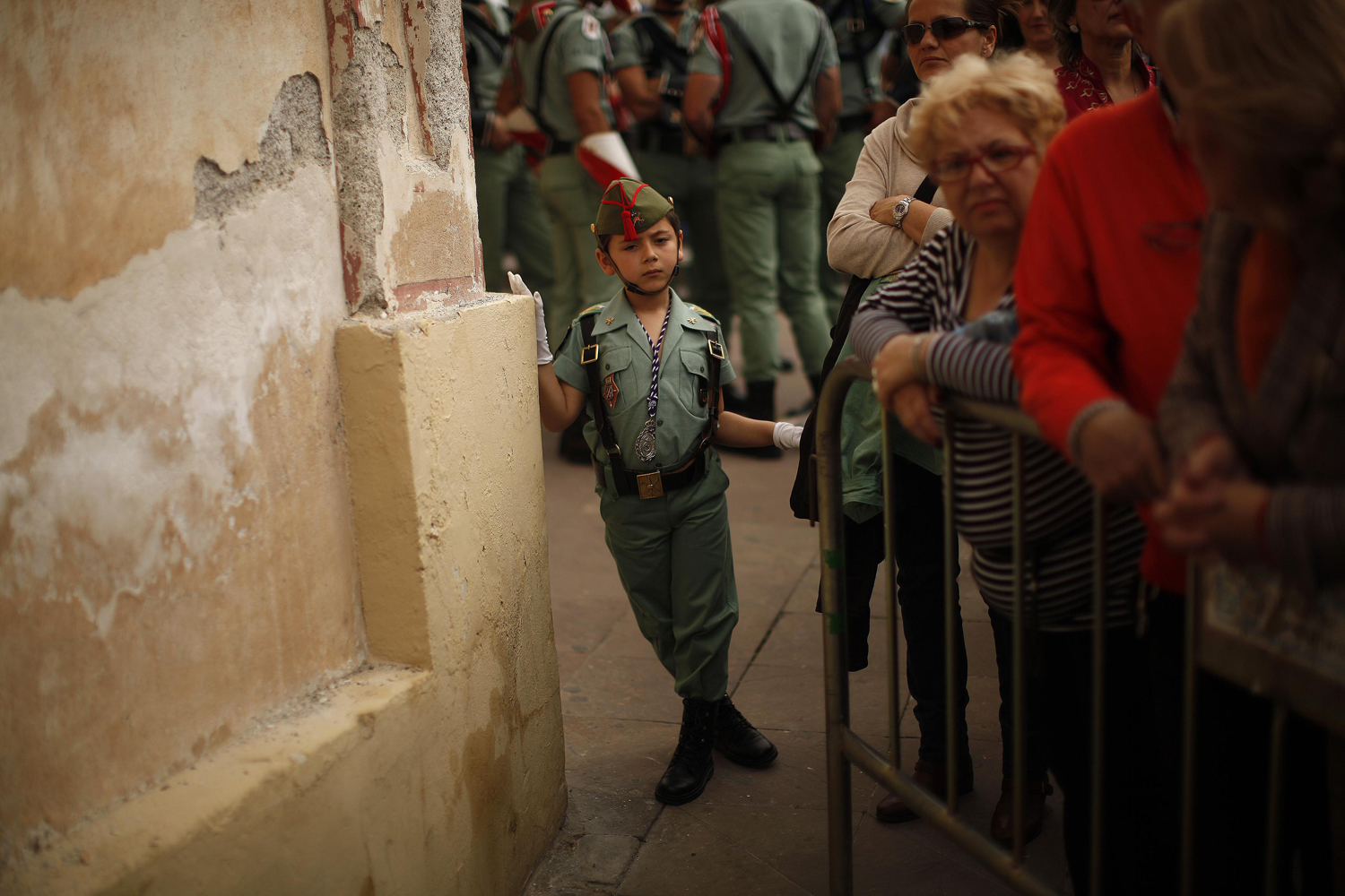 March 28, 2013. Guille, 6, dressed as a Spanish legionnaire, looks on during a ceremony where Spanish legionnaires carry a statue of the Christ of Mena before taking part in the Mena brotherhood procession in Malaga, southern Spain.