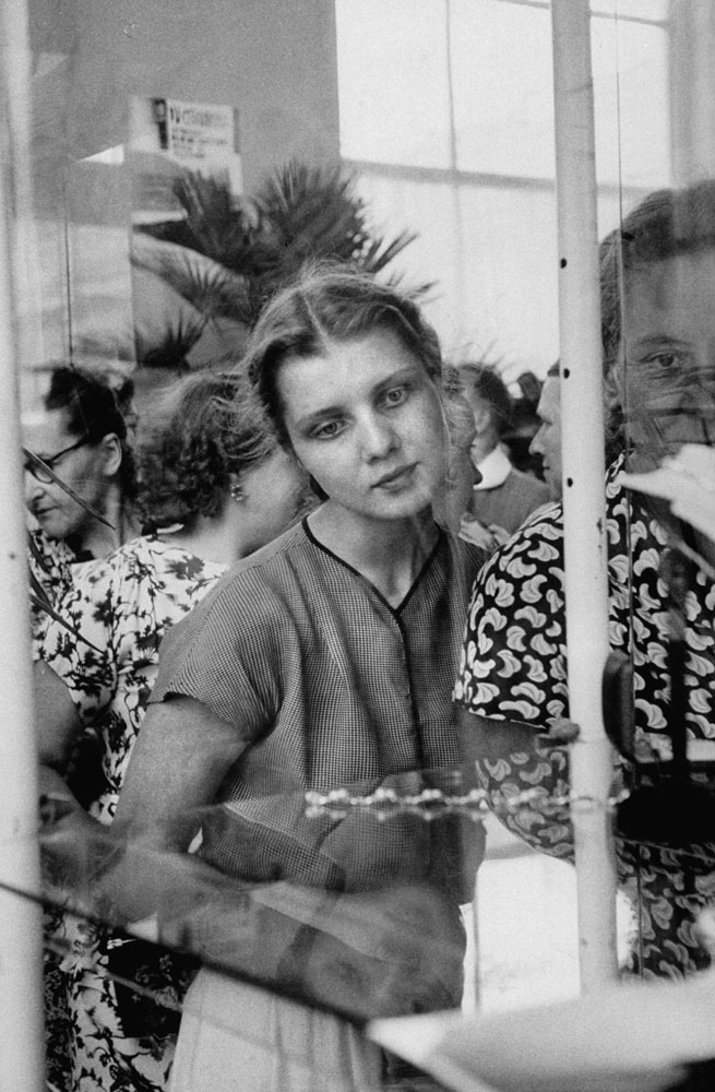 Russian woman eyes a rhinestone bracelet at a display of British fashions, 1956.