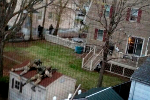 April 19, 2013. Police officers surround a house in Watertown, Massachusetts during a manhunt for suspects in the Boston Marathon bombing.