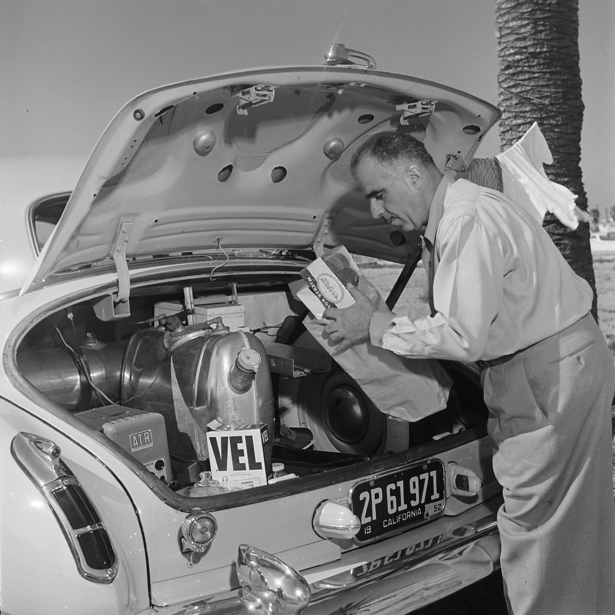 Louis Mattar pulls the makings of a meal from the trunk of his heavily modified 1947 Cadillac, San Diego, 1952.