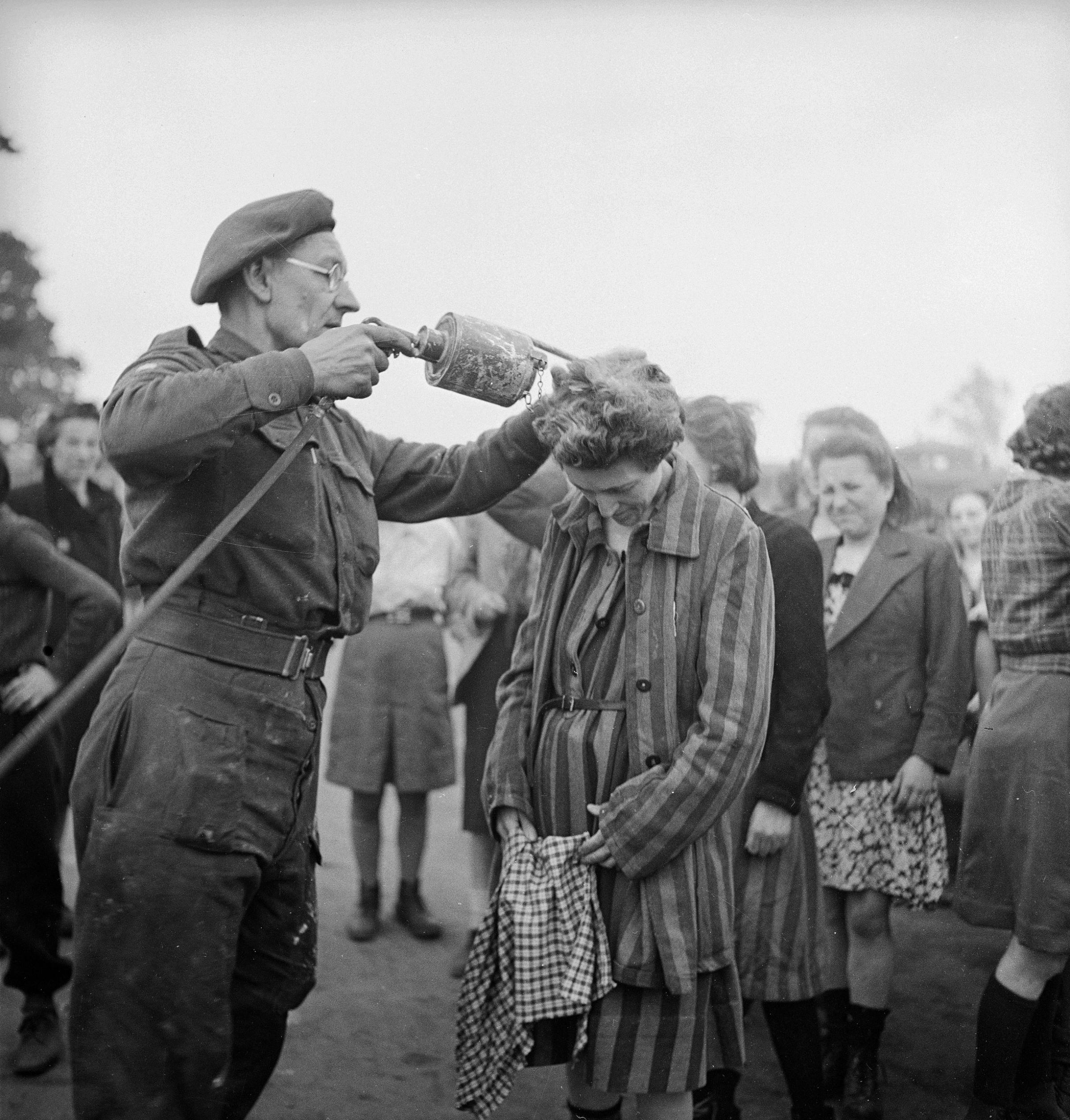 A British doctor uses DDT while delousing newly freed female prisoners at the Bergen-Belsen concentration camp, 1945.