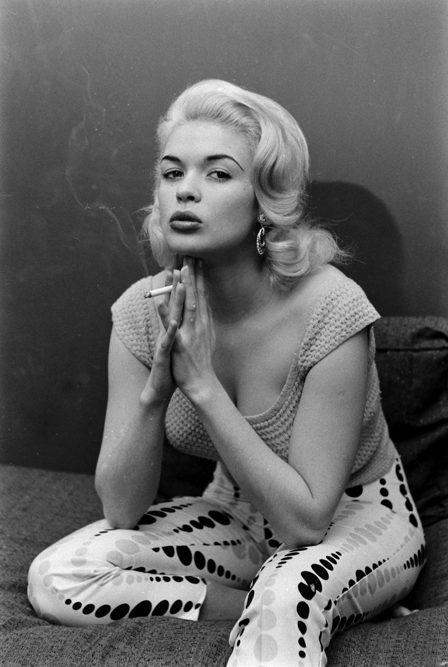 Jayne Mansfield smokes at home in Hollywood, 1956.