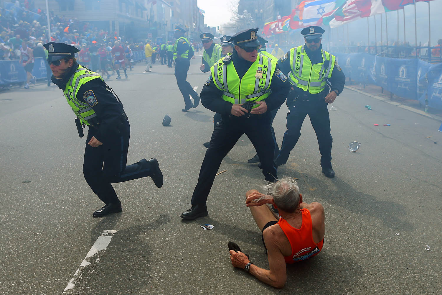 April 15, 2013. Police officers with their guns drawn hear the second explosion down the street. The first explosion knocked down a runner at the finish line of the 117th Boston Marathon.