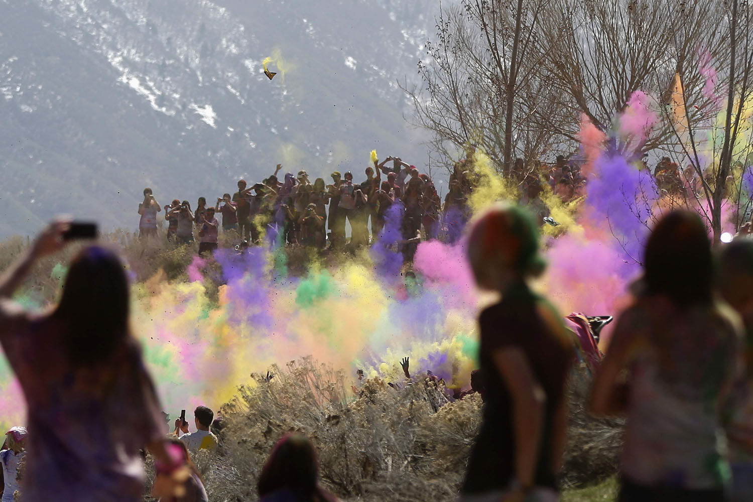 Spectators watch as participants dance and throw colored chalk during the Holi Festival of Colors at the Sri Sri Radha Krishna Temple in Spanish Fork, Utah