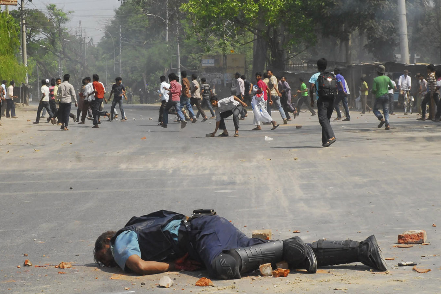 Jahangir Alam, officer in-charge of Upashahar police camp, lies on the street after Jamaat-e-Islami activists smashed pieces of bricks on his head during a clash in Rajshahi
