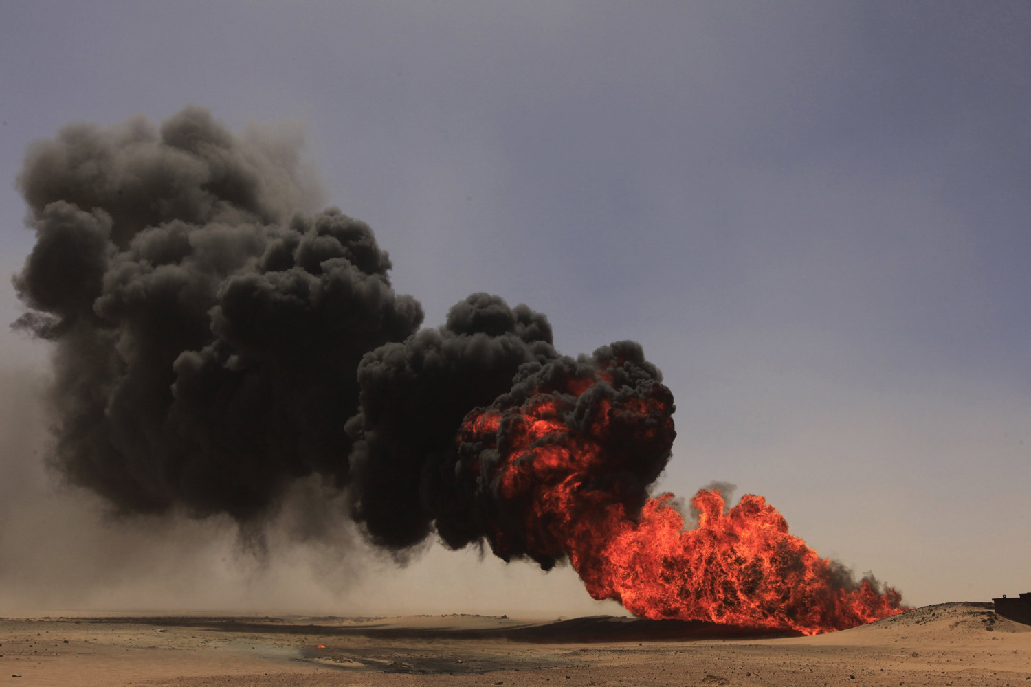 Flames and smoke rise at an oil pipeline after an explosion, south of the city of Ajdabiyah