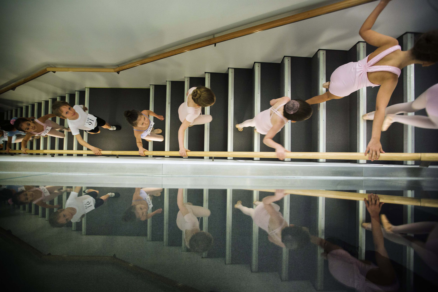 Young ballet dancers climb a staircase to take part in auditions at the School of American Ballet in New York