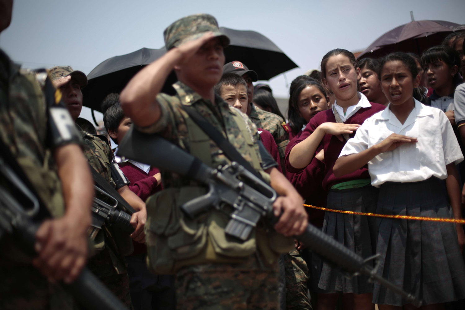 Soldiers and girls sing the national anthem during the inauguration of a new military detachment in Ciudad Quetzal