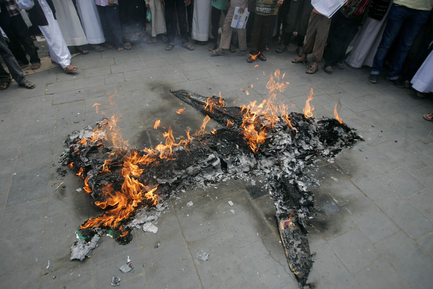 April 12, 2013. Protesters loyal to the Shi'ite al-Houthi rebel group burn an effigy of a U.S. aircraft during a demonstration to protest against what they say is U.S. interference in Yemen, including drone strikes, after their weekly Friday prayers in the Old City of Sana'a.