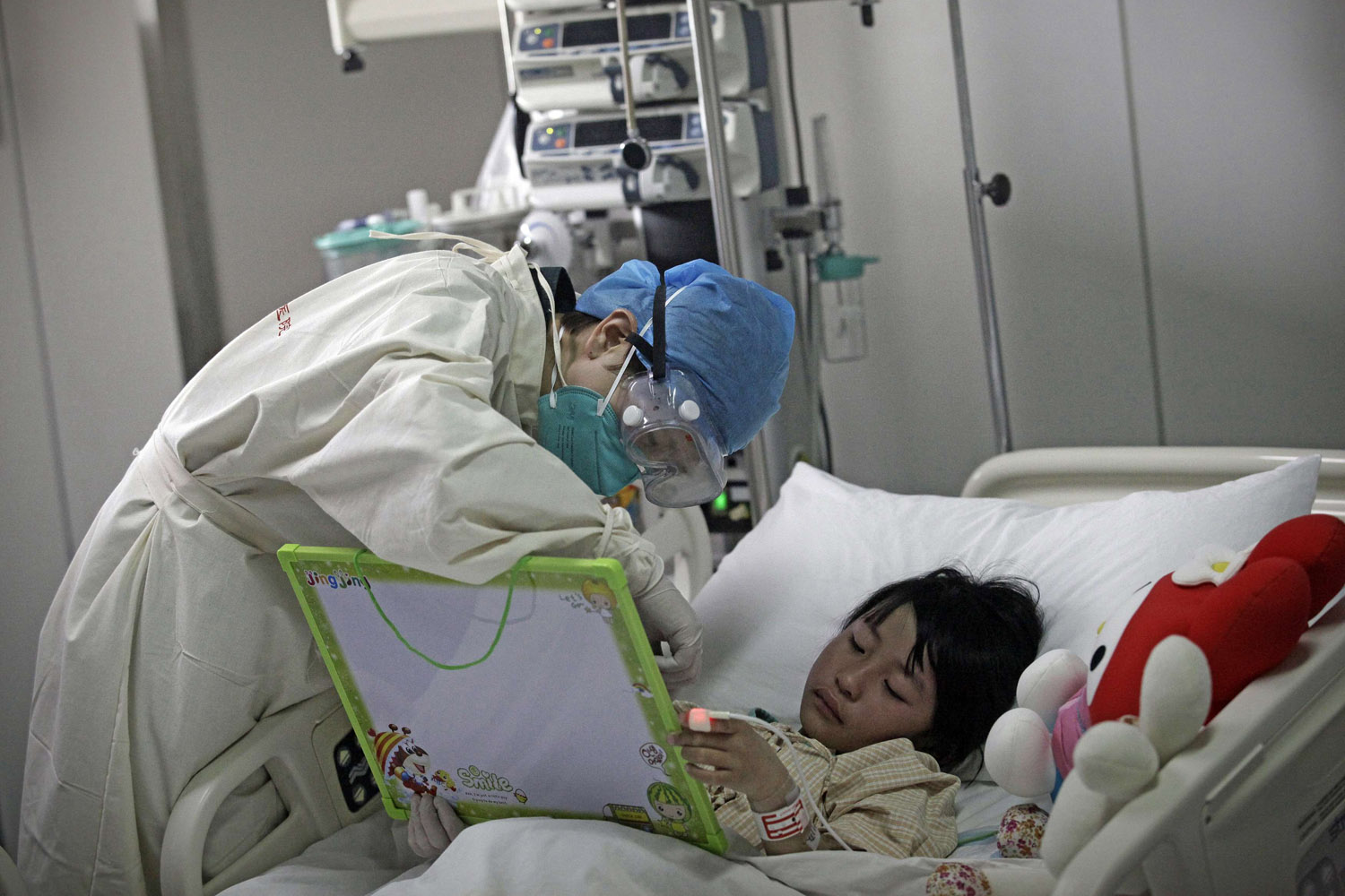 April 14, 2013. A girl infected with the new H7N9 bird flu strain draws a picture with a nurse at Ditan Hospital in Beijing. Two people in the central Chinese province of Henan have been infected by a new strain of avian influenza, the first cases found in the region, while the death toll has risen to 13 from a total of 60 infections after two more deaths in Shanghai.