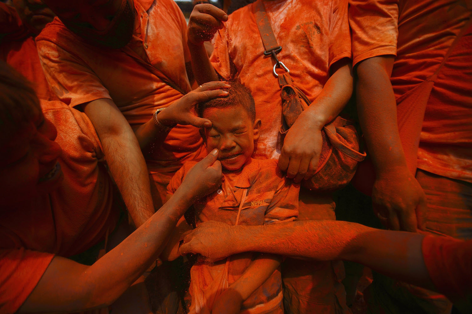 April 15, 2013. A boy is smeared with vermillion powder while celebrating  Sindoor Jatra  vermillion powder festival at Thimi, near Kathmandu. The festival is celebrated to mark the Nepalese New Year and the beginning of spring season in Nepal.