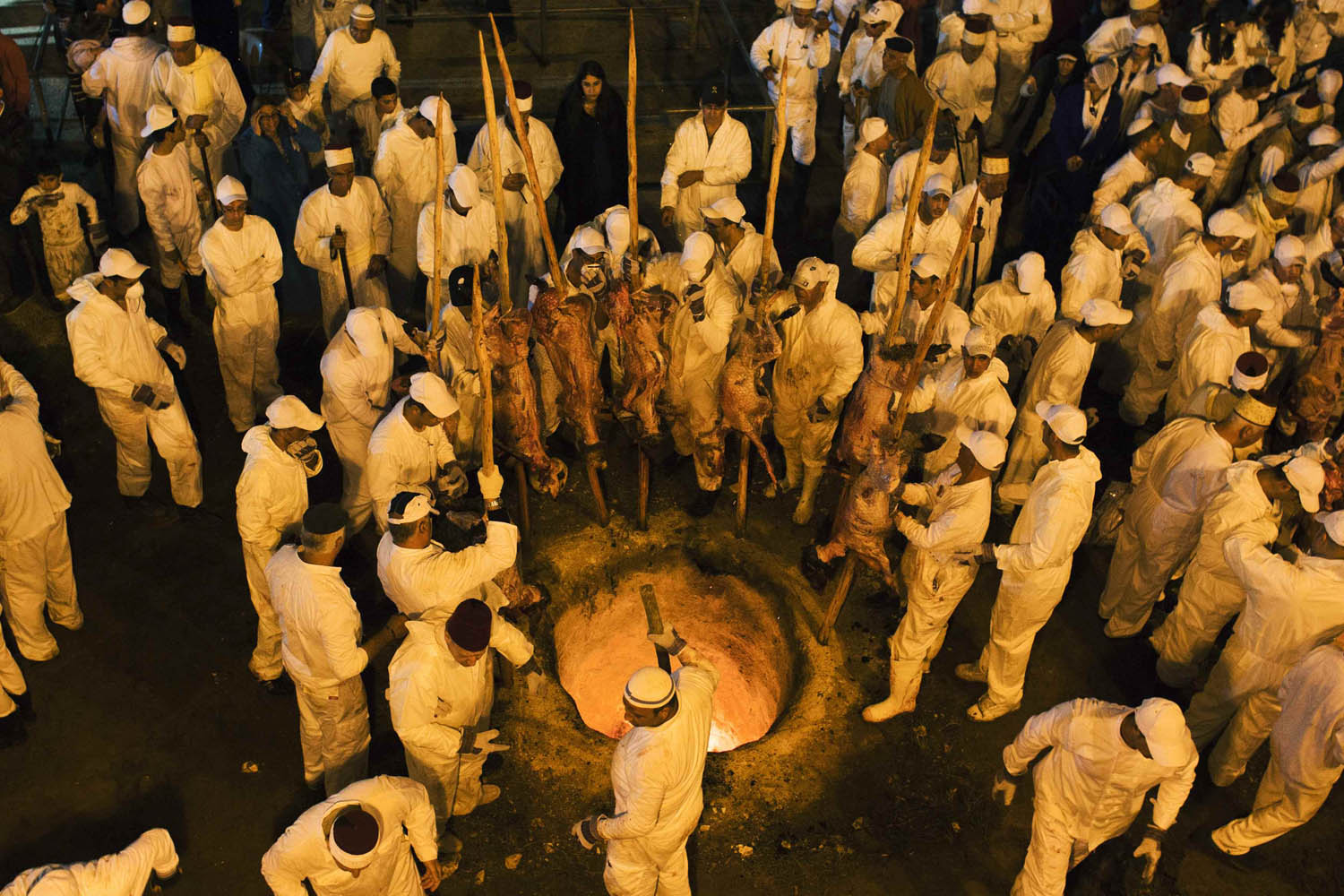 Members of the Samaritan sect place large sheep skewers into an oven during a traditional Passover sacrifice ceremony on Mount Gerizim