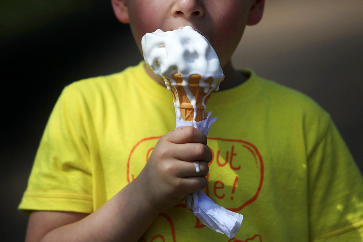 April 24, 2013. A child tucks into an ice cream during the warm weather and sunshine in St James Park, central London.