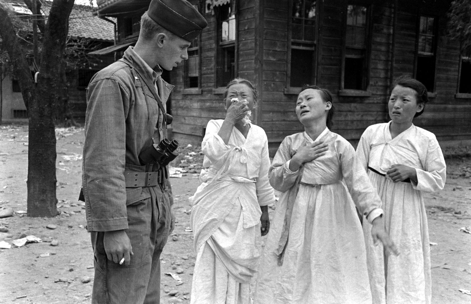 Grieving South Korean women and an international observer seen during a communist uprising, 1948.