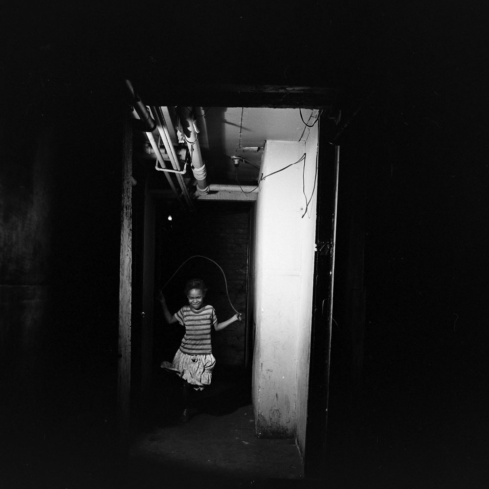 A girl plays jump rope in a Chicago tenement, 1954.