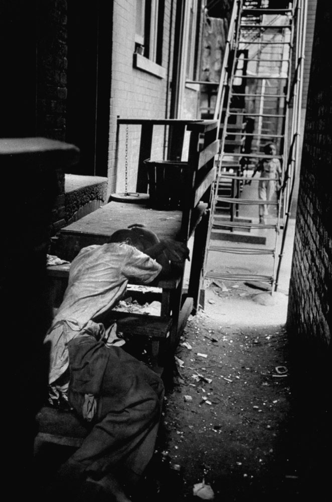 A man sleeps (or is passed out) in a Chicago alley, 1954.
