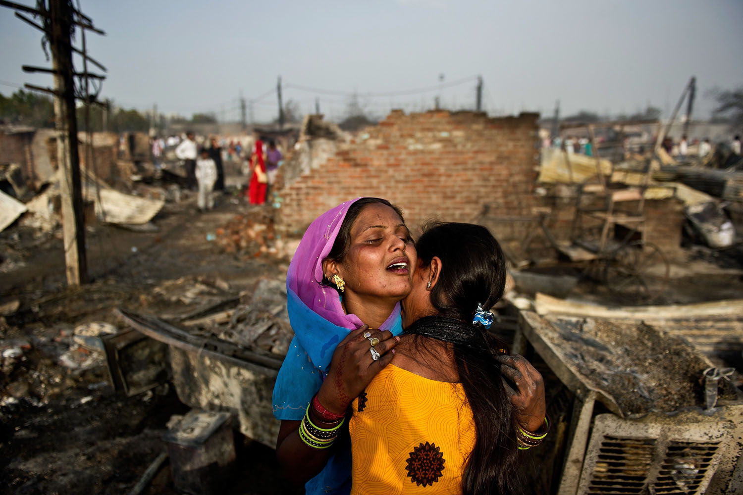 April 12, 2013. Indian slum residents weep as they stand near their burnt shanty in Bawana on the outskirts of New Delhi. A fire broke out in a slum on the outskirts of New Delhi, a local report said, with one person reported dead and another five injured.