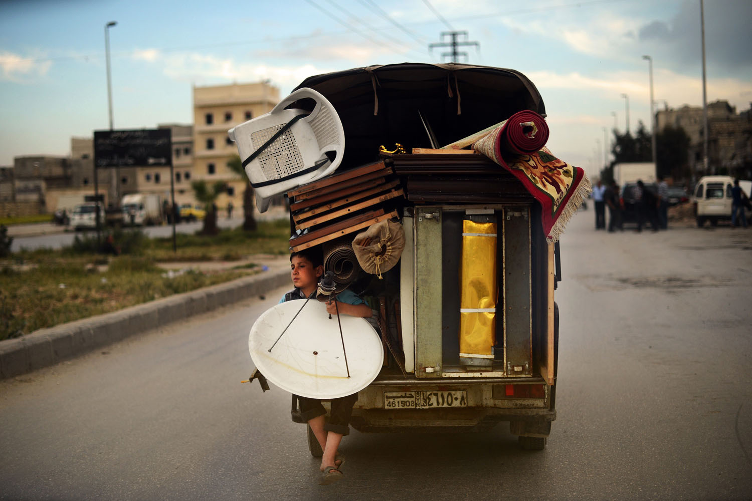 April 15, 2013. A Syrian boy holds a satellite antenna as he travels on the back of a truck in the northern Syrian city of Aleppo. In all, some 1.3 million people have so far fled Syria to neighbouring countries since the beginning of the conflict, which has cost well over 70,000 lives.
