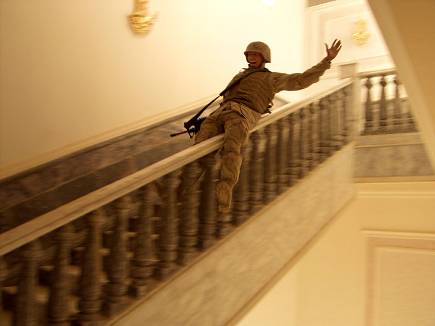 Correct Caption:Tikrit, April 14, 2003 In Saddam's hometown, a US Marine slides down a marble handrail in one of the dictator's extravagant palaces. The residence contained carpets worth hundreds of thousands of dollars and at least one golden toilet. Tikrit was the last major city to fall to Allied forces during the invasion and, despite fighting that continued through Iraq, Marines celebrated victory.Ashley Gilbertson/VII