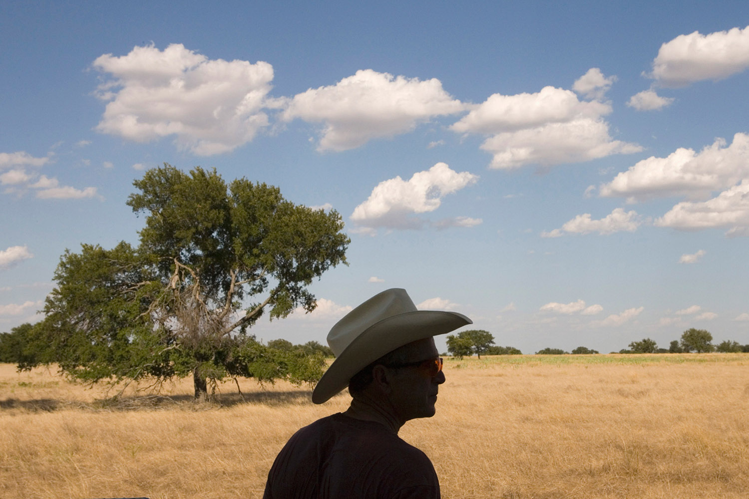 August 11, 2006. The president is silhouetted by the afternoon sky as he builds bike trails on the ranch in Crawford, Texas.