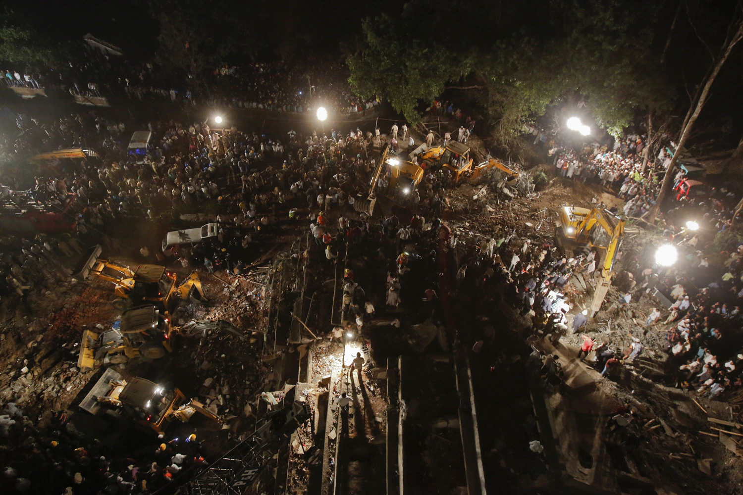 Rescue workers search for survivors at the site of a collapsed residential building in Thane