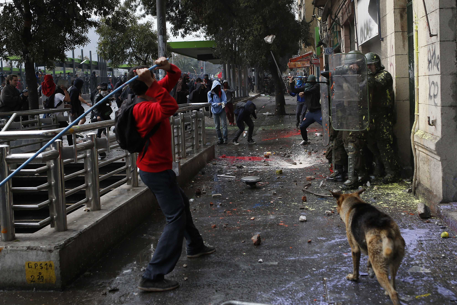 Student protesters clash with riot police officers during a rally in Santiago