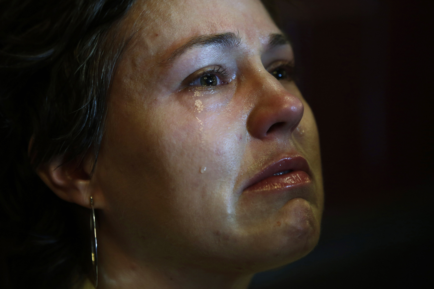 April 18, 2013. Sarah Shallbetter cries as she watches a broadcast of President Barack Obama speaking at an interfaith service at Cathedral of the Holy Cross on a video screen at the BoMA restaurant in Boston.