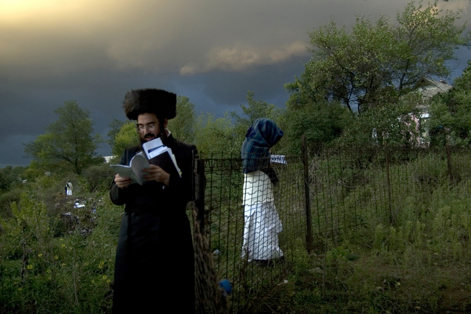 Prying Open - An oncoming storm looms above the Ukrainian sky as an Ultra-Orthodox Jewish man and woman complete their evening prayers on the eve of the Jewish holiday of Rosh Hashannah. It is rare to encounter a woman at the annual Rosh Hashannah gathering of Breslav Jewish Hasids in Uman, Ukraine. Out of the 30,000 attendants of this yearly pilgrimage, wherein Jews of all sects and nationalities come to Uman to pray at the burial-site of 17th century Rabbi Nachman, only an estimated 100 are women, myself included.