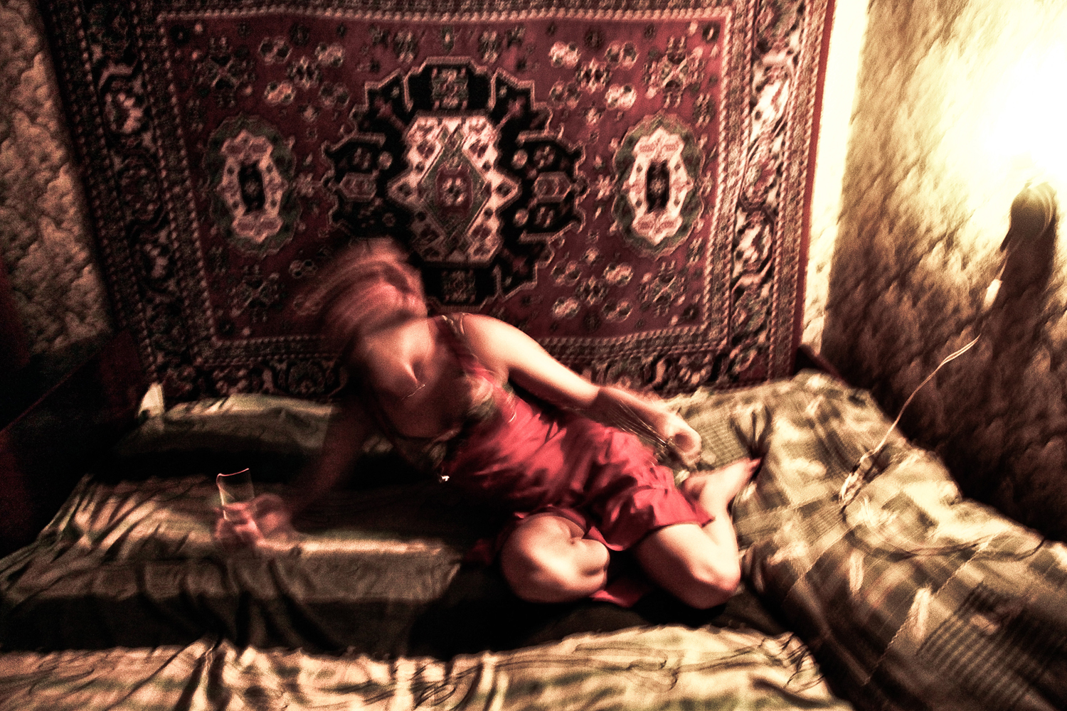 A woman believed to be a prostitute poses in her bed.