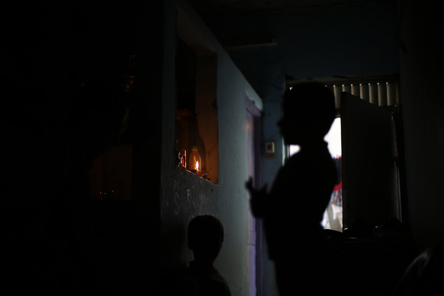 Palestinian children are seen inside their family's house during a power cut in Jabalya refugee camp