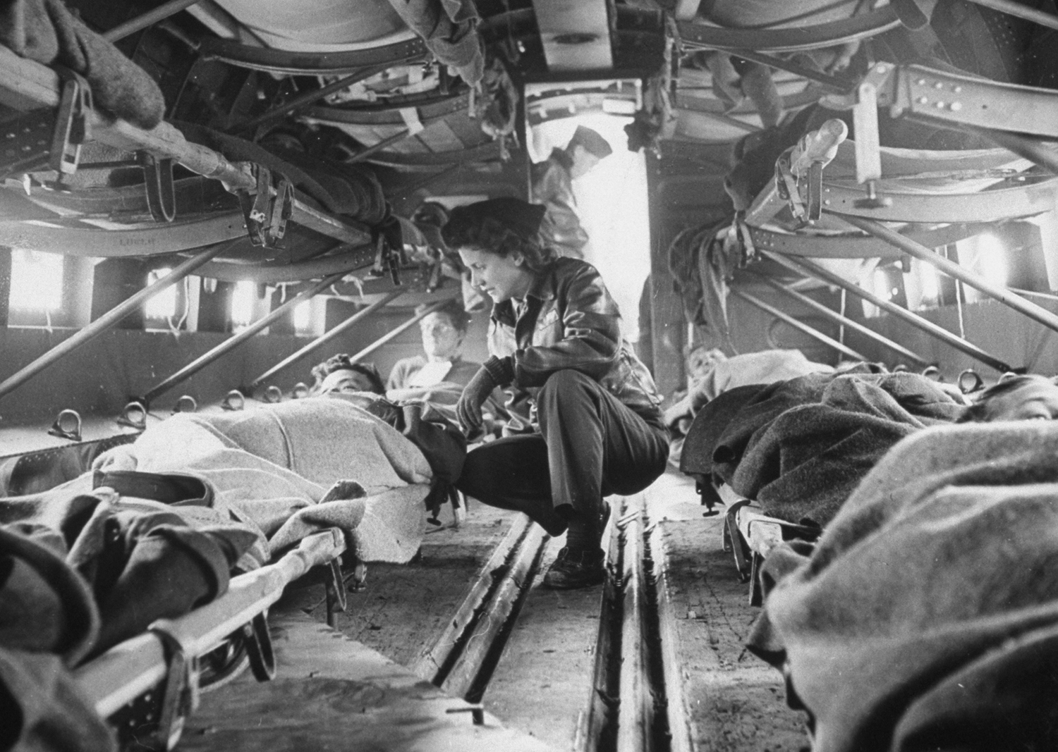 Somewhere over North Africa an American "flying nurse," Second Lieut. Julia Corinne Riley, 23, checks on patients aboard a specially outfitted C-47 transport plane, used to ferry wounded men from the battlefields to hospitals in the rear, spring 1943.