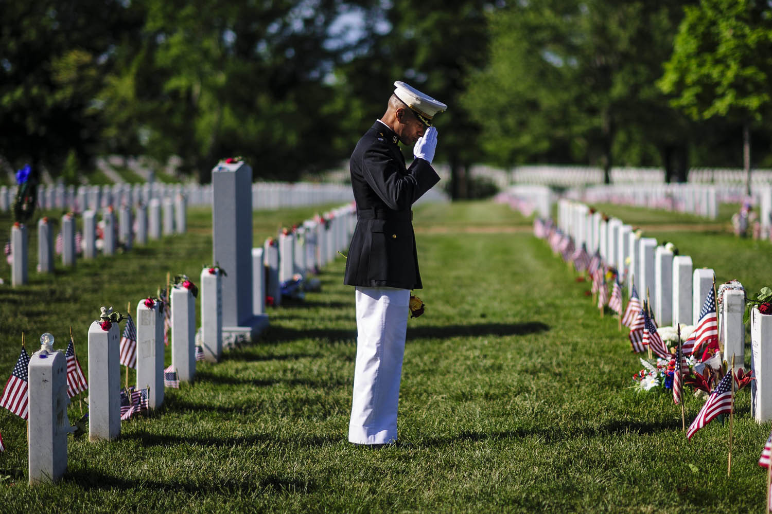 May 27, 2013. Marine Lt. Col. Cal Worth salutes as he visits the grave site of a fallen comrade during a Memorial Day visit to Arlington National Cemetery in Arlington, Virginia.