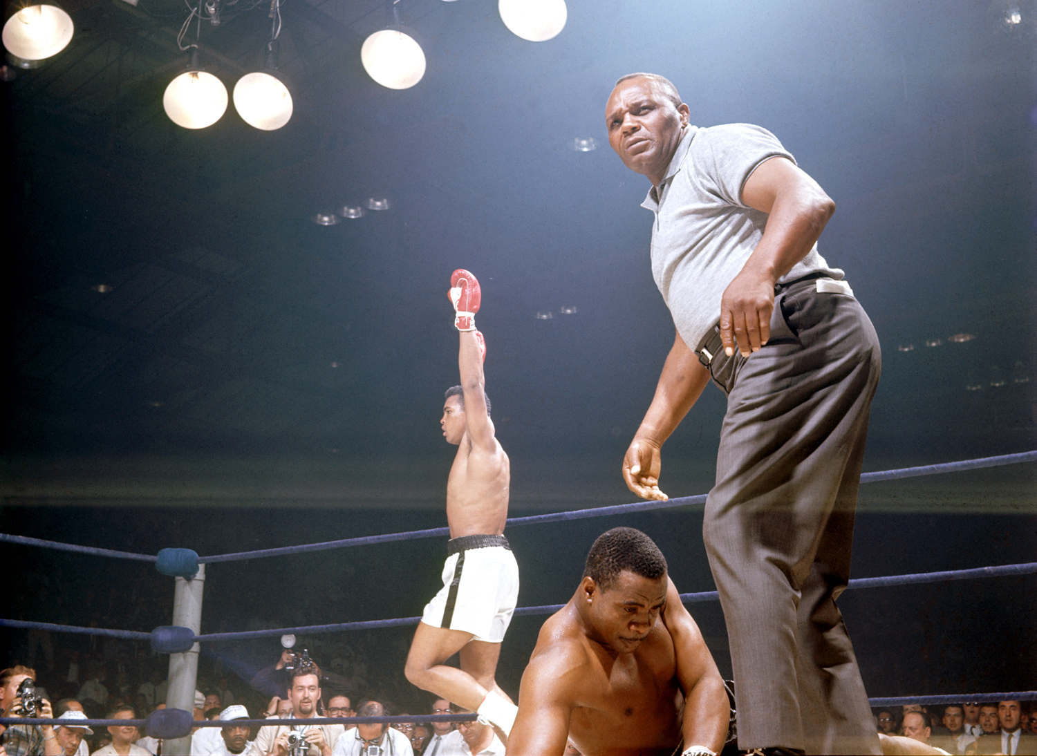 With Sonny Liston lying dazed -- or, as some would have it, pretending to be dazed -- on the canvas, Muhammad Ali exults, May 25, 1965. (Referee is Jersey Joe Walcott.)