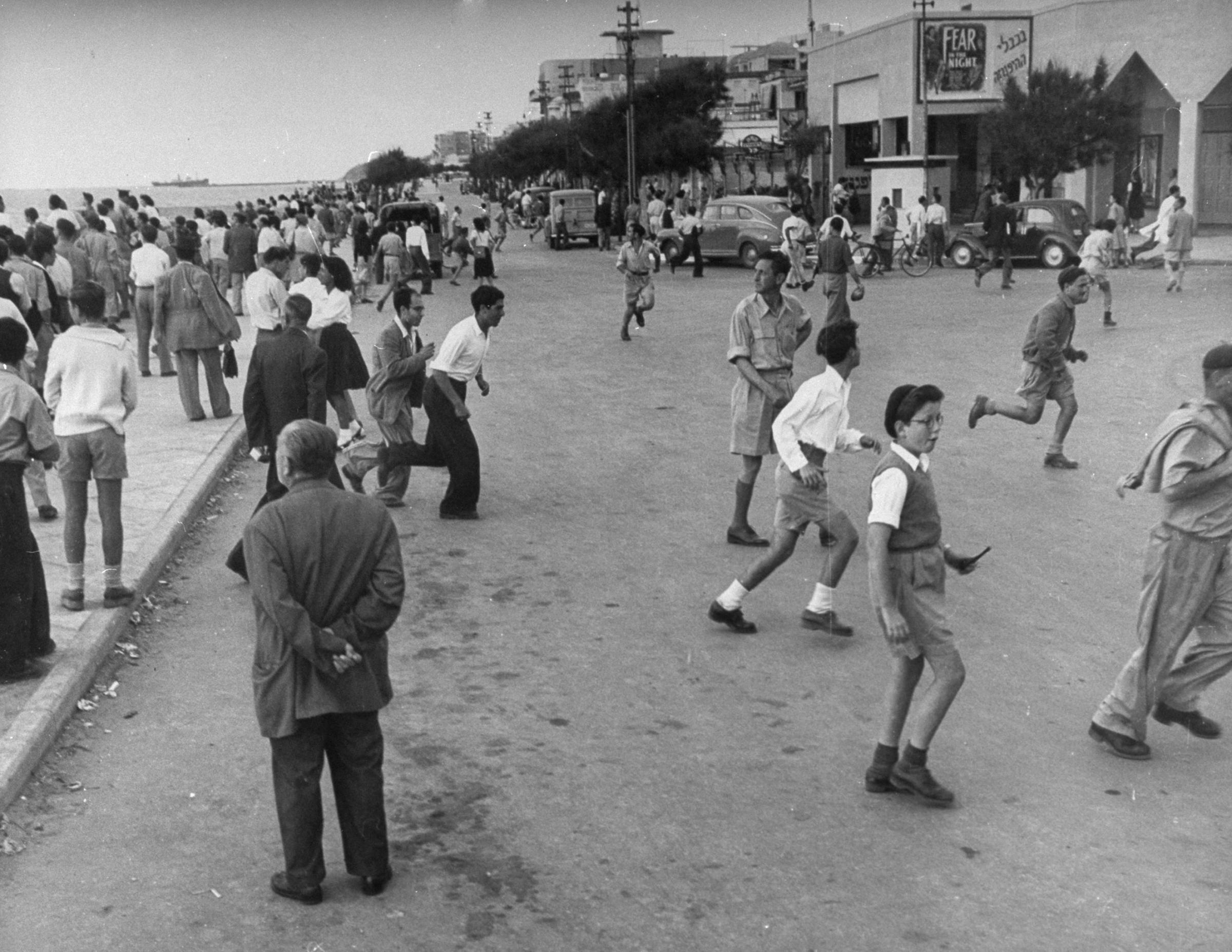 People run away from the waterfront during an air raid shortly after the establishment of the state of Israel, exact location unknown, May 1948.