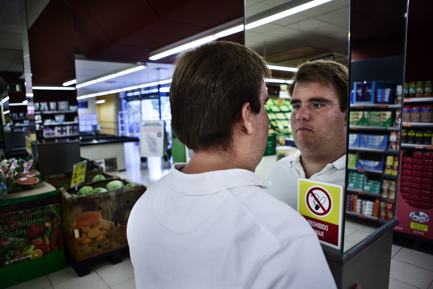 Alexander looks himself in the mirror of a supermarket. 2012 Seville, Spain Alejandro se mira en el espejo de un supermercado. Sevilla, España 2012