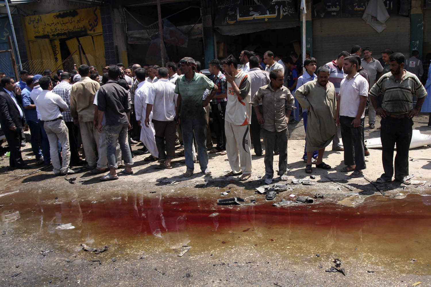 Residents look at a pool of blood after a car bomb attack in Kerbala