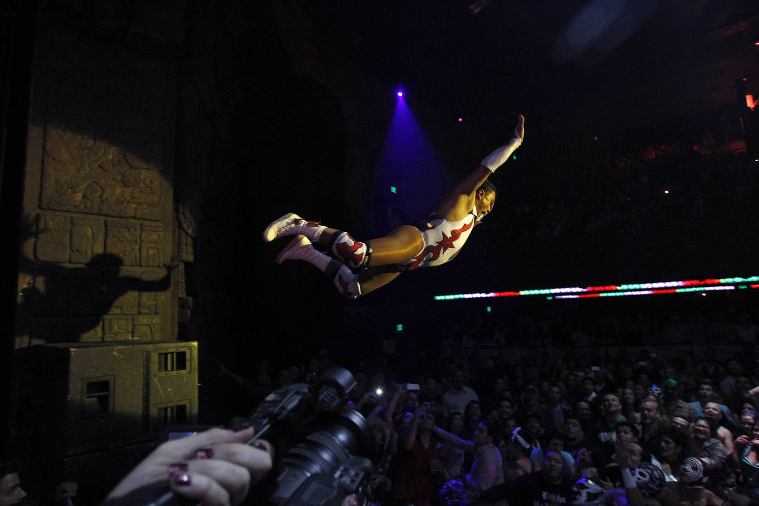 Lucha libre wrestler Cassandro leaps into the audience during the Lucha VaVOOM show as part of a Cinco de Mayo celebration at the Mayan theatre in Los Angeles