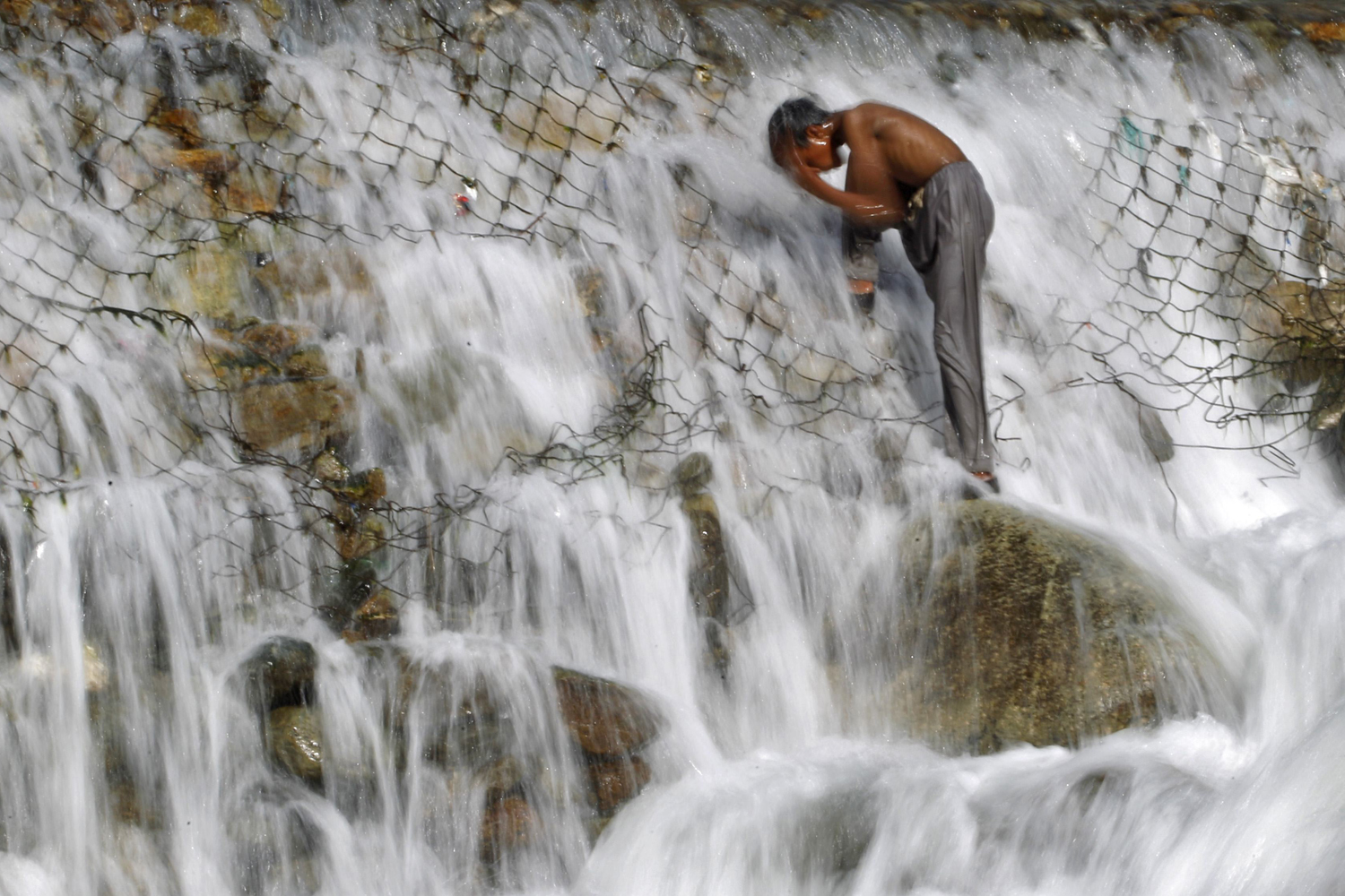 A boy bathes in a stream at Dara on the outskirts of Srinagar