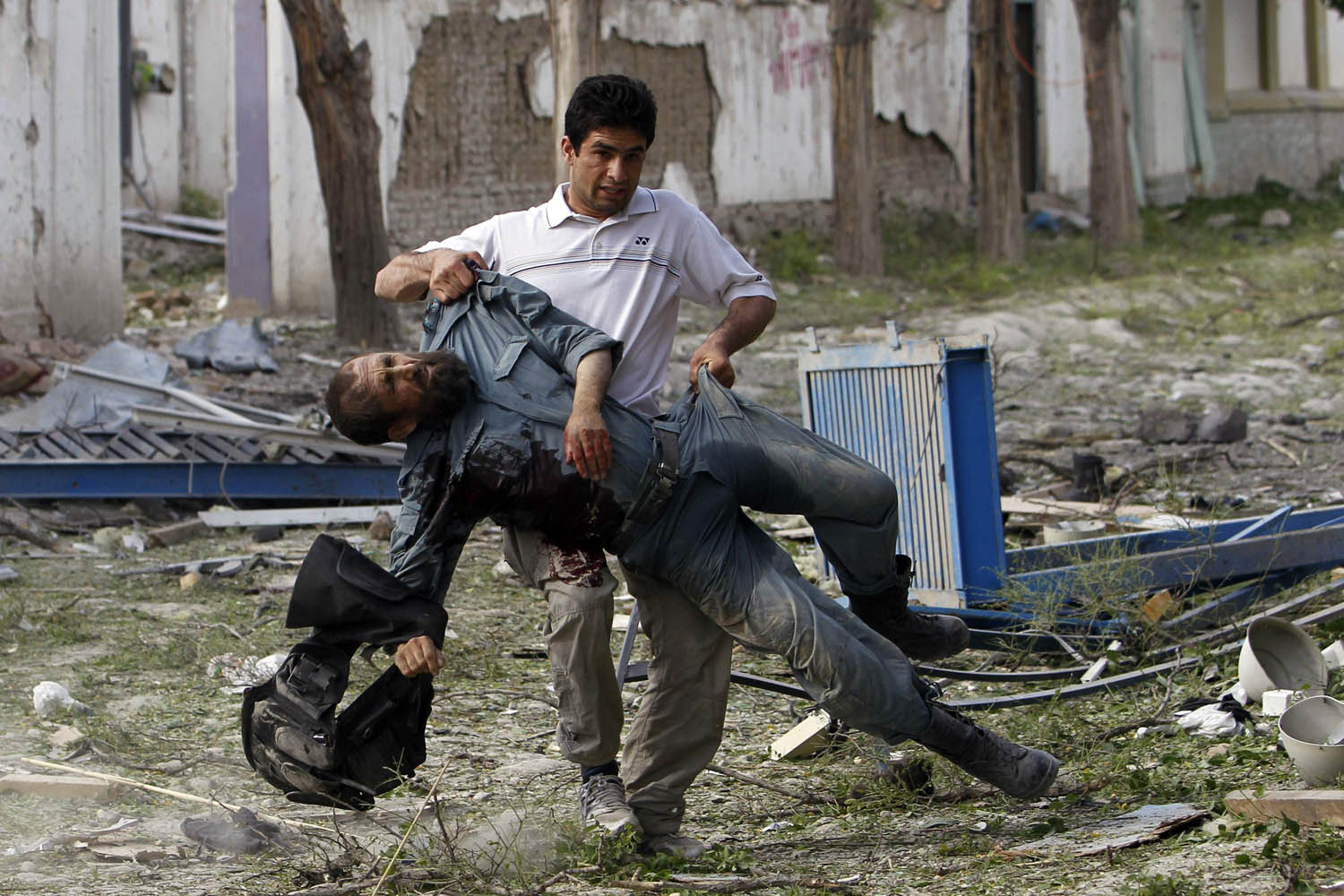 May 24, 2013. A wounded Afghan policeman is carried away from the site of an explosion in Kabul.