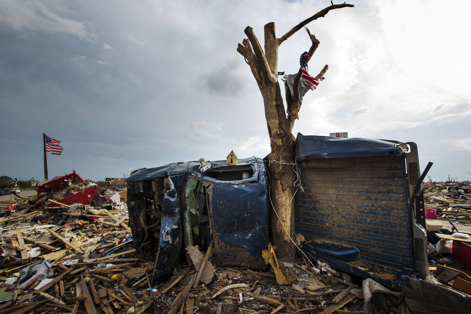 The body of a pickup truck is wrapped around a tree trunk after being thrown there by by a tornado in Moore, Oklahoma