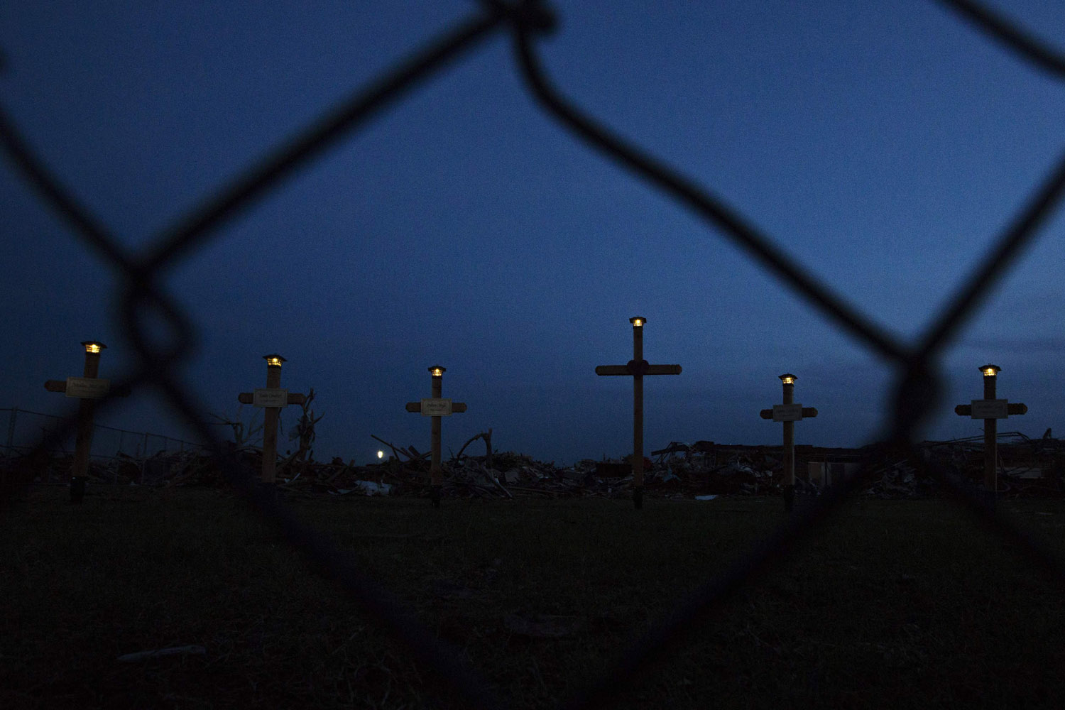 May 26, 2013. Lights shine on the tops of crosses making up a memorial outside the Plaza Towers elementary school where seven children died and several students and teachers were injured by the May 20 afternoon tornado in Moore, Okla.