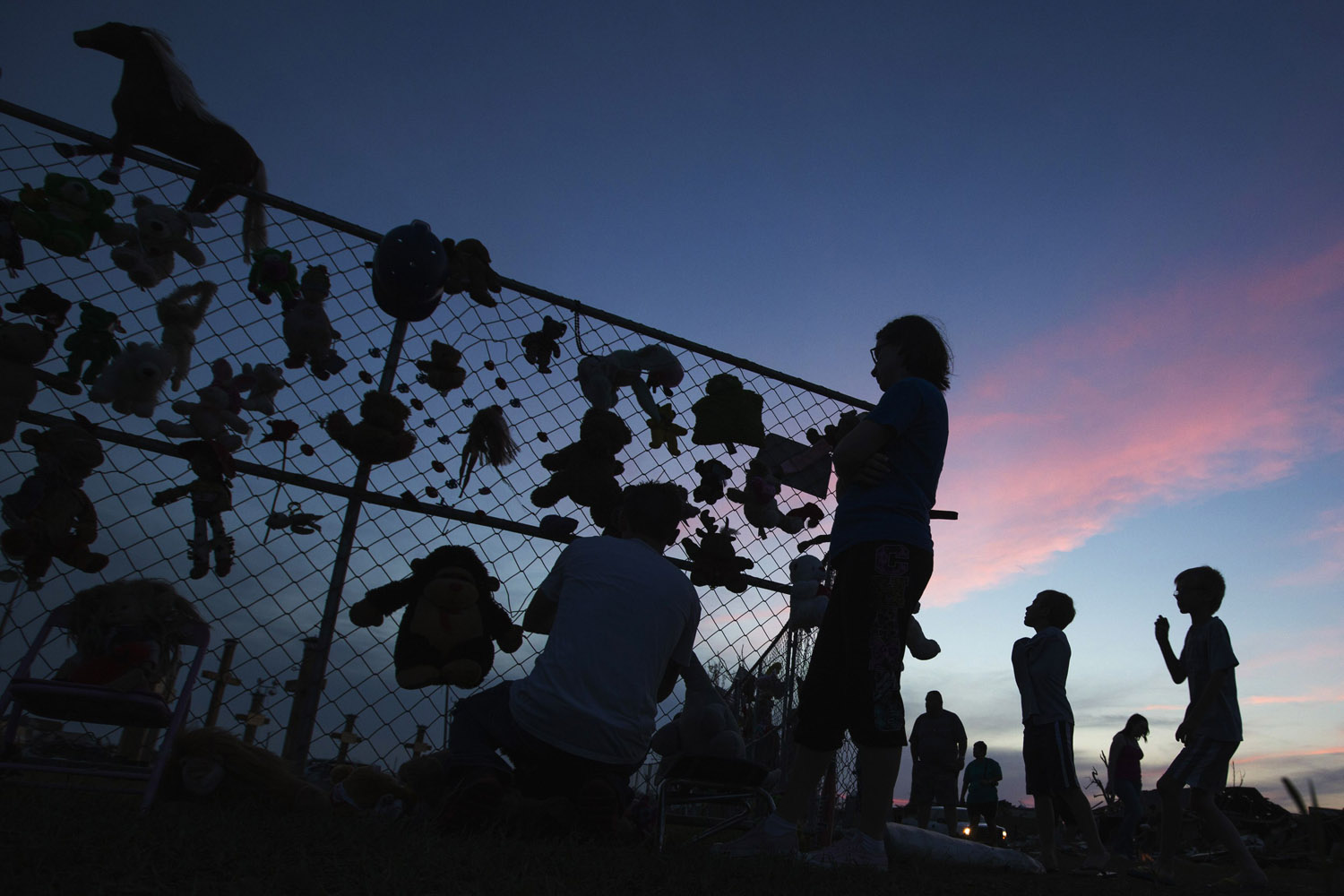 May 26, 2013. Mourners visit a chain link fence that has been made into a memorial outside the Plaza Towers elementary school where seven children died and several students and teachers were injured by the May 20 afternoon tornado in Moore, Okla.