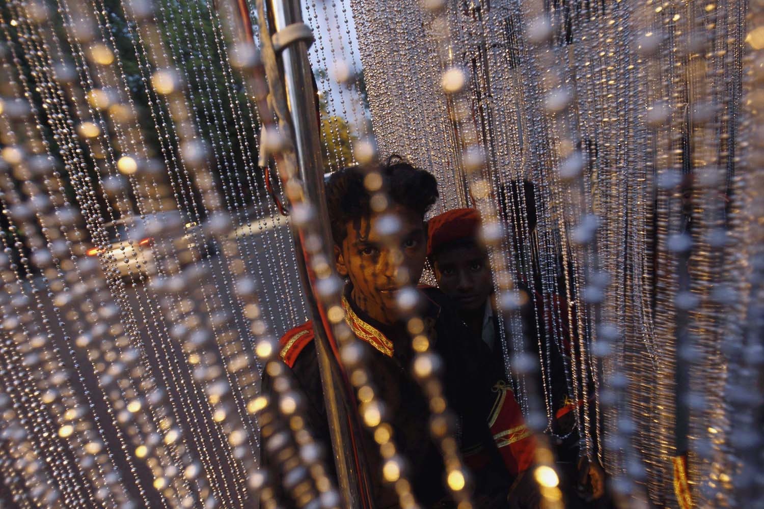 A band member carries a light prior to a wedding procession in New Delhi