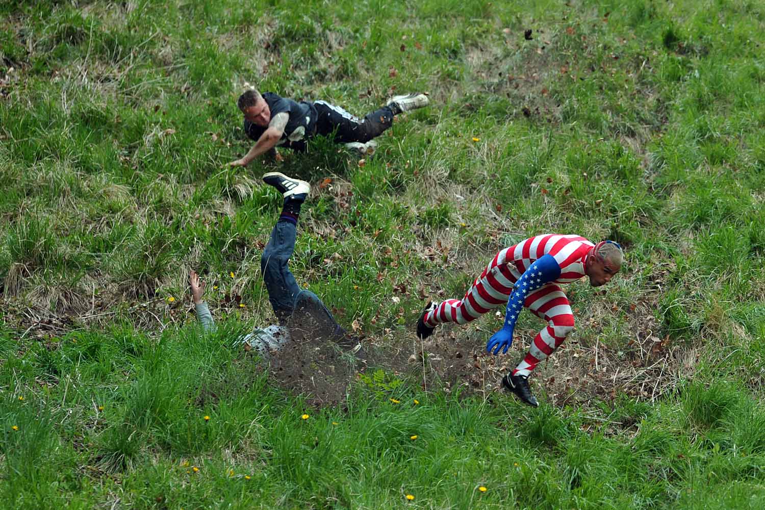 May 27, 2013. Competitors run and tumble down Coopers Hill in pursuit of a fake foam round Double Gloucester cheese during the annual cheese rolling and wake near the village of Brockworth near Gloucester in western England.